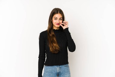 Beyaz arka planda izole edilmiş beyaz tenli genç bir kadın parmakları dudaklarında bir sır saklıyor..