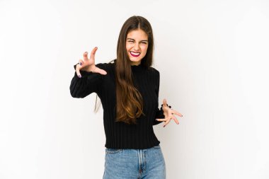 Beyaz arka planda izole edilmiş genç beyaz kadın pençelerini kedi taklidi yaparken gösteriyor, agresif bir hareket..