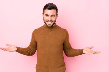 Pembe arka planı olan beyaz bir genç hoş bir yüz ifadesi sergiliyor..