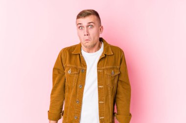 Kafkasyalı genç adam omuz silkiyor ve gözleri açık..