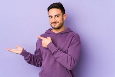 Mor arka planda izole edilmiş genç beyaz bir adam, elinde bir fotokopi alanı tutarken heyecanlanıyor..