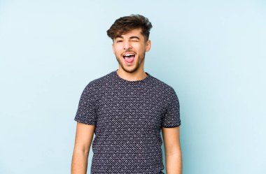 Mavi arka planda izole edilmiş genç bir Arap. Komik ve dost canlısı bir dil..