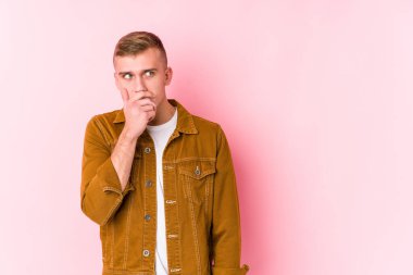 Kafkasyalı genç adam, düşünceli bakışlarını bir fotokopi odasına izole ederek ağzını eliyle kapatıyor..