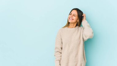 Mavi arka planda izole edilmiş genç bir kadın zaferi, tutkuyu ve coşkuyu, mutlu ifadeyi kutluyor..