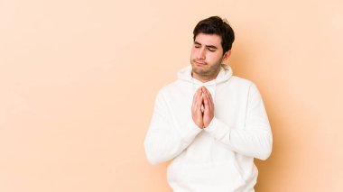 Genç adam bej rengi arka planda izole edildi. Aklında bir plan oluşturdu, bir fikir oluşturdu..