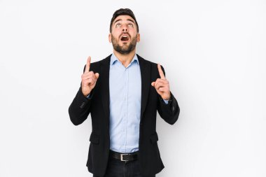 Beyaz arka planda beyaz tenli beyaz bir iş adamı ağzı açık bir şekilde üst tarafı işaret ediyor..