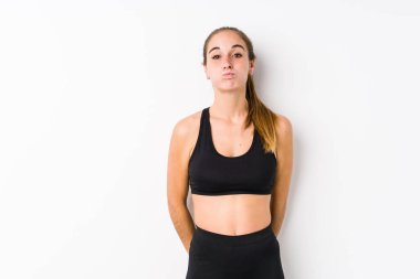 Beyaz arka planda poz veren beyaz tenli kadın yanakları patlatıyor, yorgun bir ifade takınıyor. Yüz ifadesi kavramı.