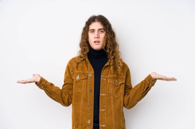 Uzun saçlı adam yalnız poz veriyor. Kafası karışık ve omuz silkiyor. Kopya alanını tutmak için..