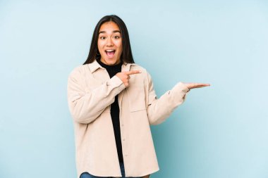 Mavi bir arka planda izole edilmiş genç bir kadın..