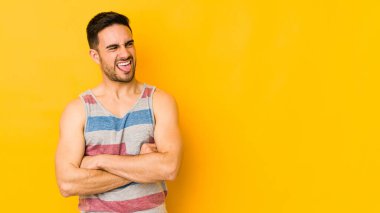 Genç beyaz adam sarı fırında izole edilmiş komik ve dost canlısı bir dil uzatıyor..