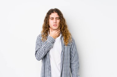 Yalnız poz veren uzun saçlı genç adam virüs ya da enfeksiyon yüzünden boğazında ağrı hissediyor..