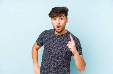 Genç Arap bir adam mavi bir arka planda izole bir fikir, ilham konsepti var.
