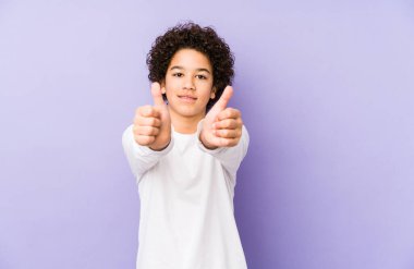 Afrika kökenli Amerikalı küçük bir çocuk. Başparmakları havada, bir şey için tezahürat yapıyor. Destek ve saygı kavramı..