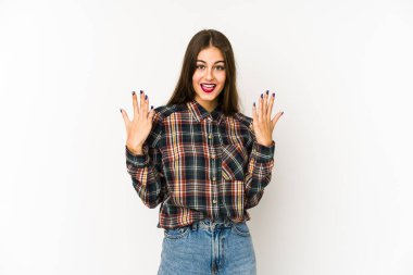 Beyaz arka planda izole edilmiş beyaz tenli genç kadın on numarayı elleriyle gösteriyor..