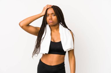 Genç Afro-Amerikan spor kadını yalnız başına, yorgun ve uykulu bir şekilde elini başının üstüne koyuyor..