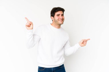 Beyaz arka planda izole edilmiş genç adam farklı kopya alanlarını gösteriyor, birini seçiyor, parmaklarıyla gösteriyor.