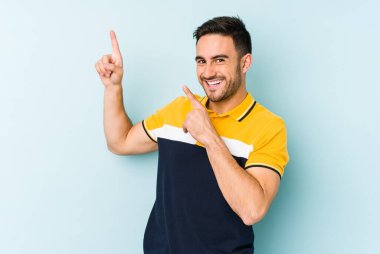 Genç beyaz adam mavi arka planda izole edilmiş dans ediyor ve eğleniyor..