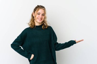 Beyaz arka plandaki genç beyaz kadın hoş bir ifade sergiliyor..