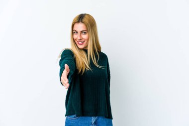 Beyaz arka planda izole edilmiş genç sarışın kadın selamlaşmak için kameraya elini uzatıyor..