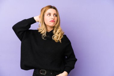 Sarışın genç bir kadın kafasının arkasına dokunup düşünüyor ve bir seçim yapıyor..