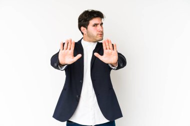 Beyaz arka planda izole edilmiş genç bir iş adamı elini uzatmış, dur işareti göstererek seni engelliyor..
