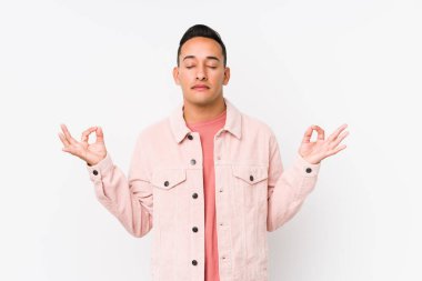 Genç Latin adam izole edilmiş poz veriyor. Sıkı çalışma gününden sonra rahatlıyor. Yoga yapıyor..