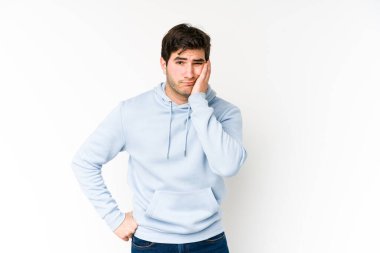 Beyaz arka planda izole edilmiş, üzgün ve dalgın hisseden, kopyalama alanına bakan genç adam..