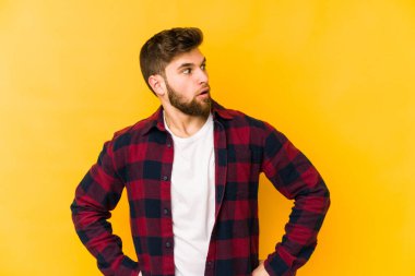 Sarı arka planda izole edilmiş genç beyaz adam gülümseyen, neşeli ve keyifli görünüyor..