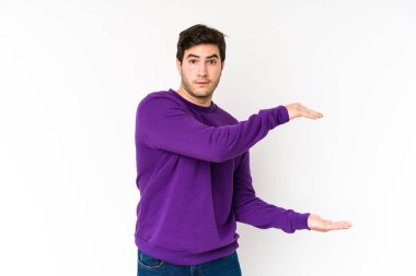 Beyaz arka planda izole edilmiş genç adam elleri arasında bir kopya alanı tutarken şok ve hayrete düştü..