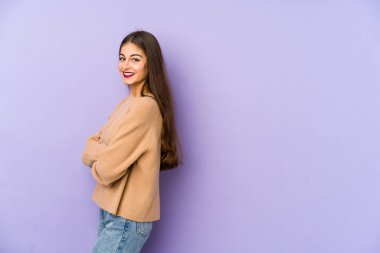 Mor arka planda izole edilmiş genç beyaz kadın mutlu, güler yüzlü ve neşeli..