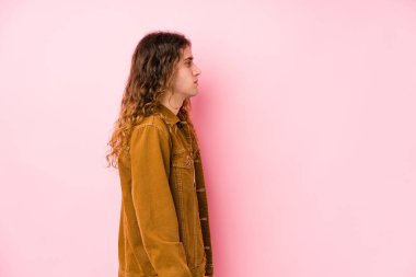 Genç, uzun saçlı adam, yanlamasına poz veriyor, sola bakıyor..