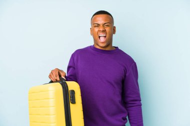 Elinde bavul tutan genç bir gezgin öfkeli ve agresif çığlıklar atıyor..