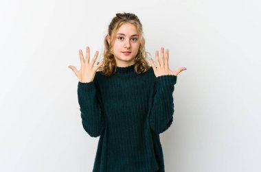 Beyaz arka plandaki genç beyaz kadın on numarayı elleriyle gösteriyor..