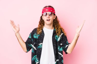 Genç beyaz bir adam yalnız başına. Hoş bir sürpriz bekliyor, heyecanlı ve el kaldırıyor..