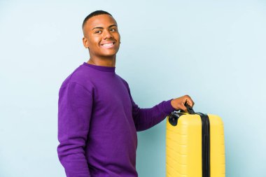 Elinde bavul tutan genç bir gezgin gülümseyen, neşeli ve keyifli bakışlarını bir yana bırak..