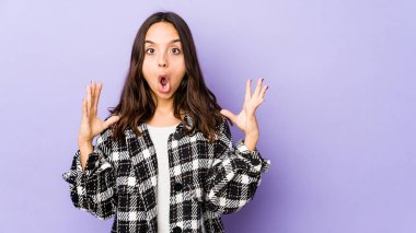 Latin kökenli genç bir kadın zaferi ya da başarıyı kutluyor, şaşırıyor ve şok oluyor..