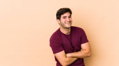 Bej arka planda yaşayan genç adam gülüyor ve eğleniyor..