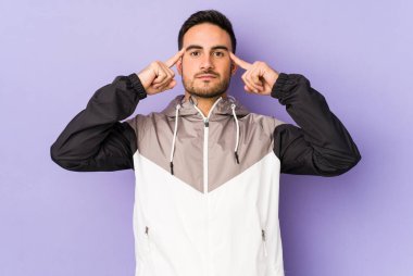 Morarmış arka planda izole edilmiş genç beyaz adam bir göreve odaklanmış, parmaklarını işaret ediyor..