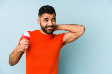 Elinde dondurma tutan genç latin adam kafasının arkasına dokunuyor, düşünüyor ve bir seçim yapıyor..