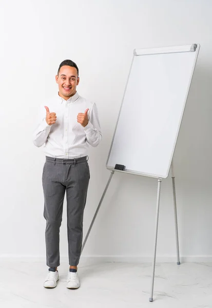 Young Latin Coaching Man Whiteboard Isolated Raising Both Thumbs Smiling — Stock Photo, Image