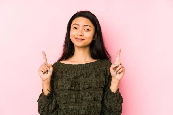 Mulher Chinesa Jovem Isolado Fundo Rosa Indica Com Ambos Dedos — Fotografia de Stock