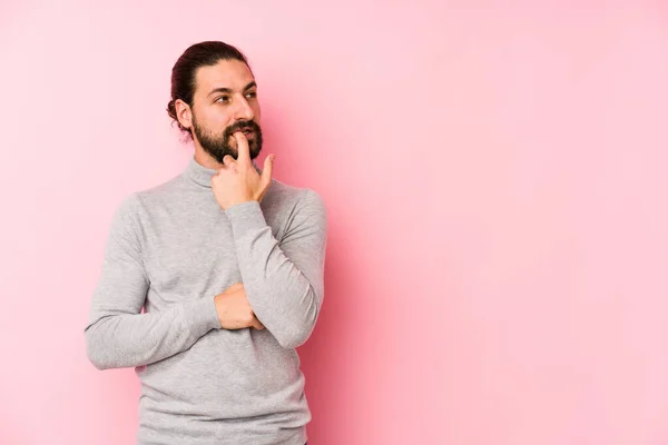 Joven Hombre Pelo Largo Aislado Sobre Fondo Rosa Relajado Pensando — Foto de Stock