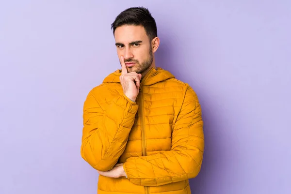 stock image Young caucasian man isolated on purple background contemplating, planning a strategy, thinking about the way of a business.