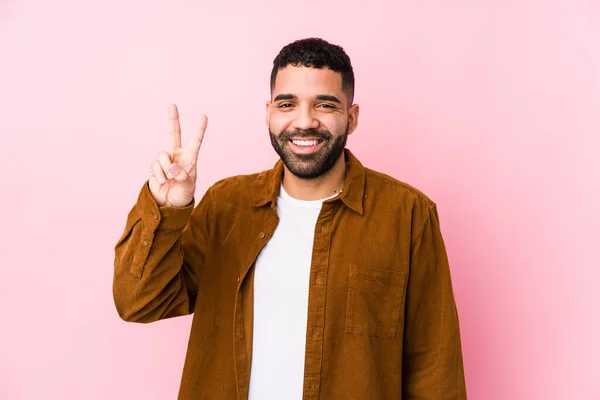 Mladý Latinský Muž Růžovém Pozadí Izolované Ukazuje Vítězství Znamení Široce — Stock fotografie