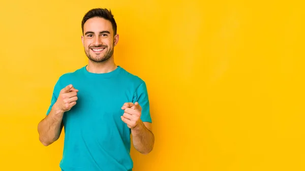Young Caucasian Man Isolated Yellow Bakground Pointing Front Fingers — Stock Photo, Image