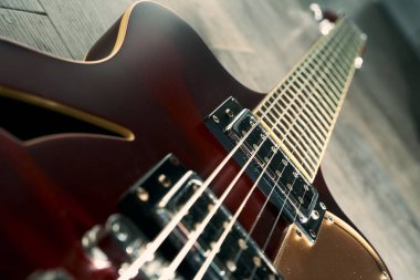 Gri ahşap zeminde kırmızı retro yarı içi boş elektro gitar