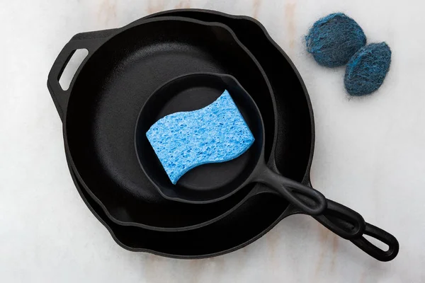 Stacked Cast Iron Skillets Sponge Steel Wool Marble Countertop — Stock Photo, Image