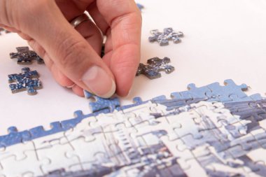 Kadın elleri yarı birleştirilmiş bulmacanın parçalarını yerleştiriyor