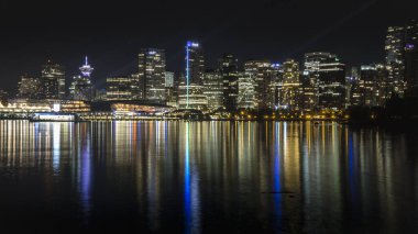 Gece Vancouver 'ı su üzerinde inanılmaz bir yansıması var. Stanley Parkı 'ndan çekilen güzel renkler ve binalar