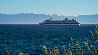 Cruise Ship leaving Victoria BC Canada with mountains behind clipart